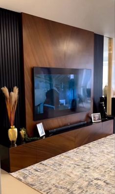 a large flat screen tv mounted to the side of a wooden entertainment center in a living room