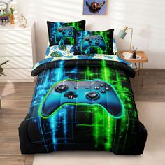 a bed covered in a blue and green comforter with two video game controllers on it