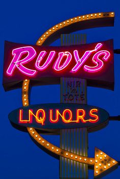 the neon sign for ruby's liquors is lit up