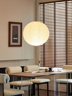 a dining room table with chairs and a lamp hanging over it