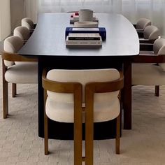 a table with chairs and a book on top of it in front of a window