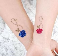 two matching tattoos with roses on their wrist and the other one has an arrow in it