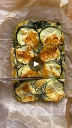 a piece of bread with zucchini and cheese on it next to a knife