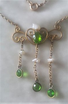 This elegant necklace is gold plate on brass. It is 16 inches long and the central part drops 1 3/4 inches.  The green glass stone are accentuated by natural Mississippi pearls. This was made when the pearls were plentiful, but they are rare now. C. 1890 and American. Follow me on instagram@jettesjewels. Green Pearl Pendant Necklace For Formal Occasions, Formal Green Necklace With Pearl Pendant, Elegant Green Dangle Drop Necklace, Vintage Dangle Pearl Drop Necklace, Vintage Pearl Drop Dangle Necklace, Vintage Green Dangle Necklaces, Antique Green Necklaces With Vintage Charm, Vintage Charm Green Brass Necklaces, Green Brass Necklaces With Vintage Charm