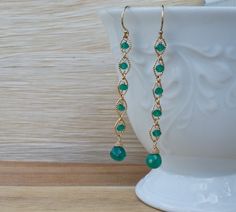 "Delicately polished, these Green Onyx are the perfect day-to-night earring. They have an incredible understated beauty that will make you want to pull your hair back and let them shine. Each facet of the Green Onyx seems to catch the light in the room making them glow with a lush beauty. Each round link, in either 14K Gold Fill or Sterling Silver, has one of these luminous stones nestled in its embrace.Balanced against these links is a stunning faceted Green Onyx tear drop at its base. Each gem Elegant Wire Wrapped Earrings For May Birthstone, Dressy Earrings, Girly Bracelets, Linear Earrings, Wire Jewelry Earrings, Beaded Jewelry Earrings, Framed Jewelry, Bijoux Fil Aluminium, Hair Back