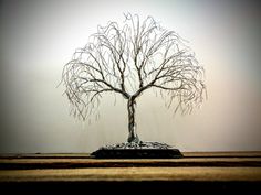 a wire tree sitting on top of a wooden table