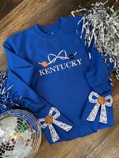 How adorable are these STATE bow basketball sweatshirts. We are obsessed with the design and the cute little bows on the side of the sweatshirt. Hand cut to make the bow stand out and pop. Complete the look with leggings, bike shorts or jeans. XS-4XL YXS -YL handmade by our staff made to order premium cotton blend unisex sizing wash on cold hang to dry sweatshirt option only PLEASE LEAVE SCHOOL COLORS AND SCHOOL/ STATE IN THE NOTE BOX AT CHECKOUT ADULT AND CHILDDREN SHIRT COLORS MAY SLIGHTLY DIF Bow Stand, Basketball Sweatshirts, Senior Night, Note Box, Country Western, School Colors, Bike Shorts, Pet Clothes, Dress Accessories