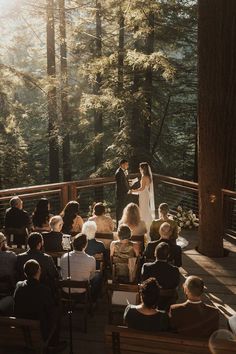 a bride and groom standing at the end of their wedding ceremony in front of a forest