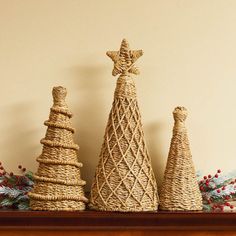 three wicker christmas trees sitting on top of a mantle