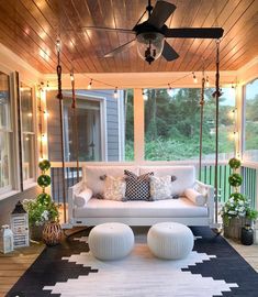 a white couch sitting on top of a black and white rug under a ceiling fan