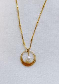 Classic and timeless in design and nature - the Whirl Necklace is a special piece made to make new memories in. 14 K gold-filled White Freshwater Pearl Gold 14k Everyday Pearl Necklace, Everyday Gold Pearl Necklace In 14k Gold, Everyday 14k Gold Pearl Necklace In Gold, Yellow Gold Brass Jewelry With Pearl Charm, 14k Gold-filled Round Pearl Pendant Jewelry, Brass Box Chain Necklace, Nickel Free Yellow Gold Necklace For Everyday, 14k Gold-filled Pearl Pendant Necklace, Everyday Yellow Gold Charm Necklace With Pearl Pendant