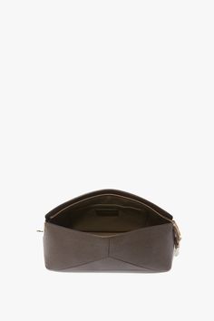 This textured calf leather Victoria Clutch is a favourite of Victoria’s. Presented in utilitarian Khaki, it has a sleek silhouette with structured body and softly rounded top for a contemporary blend of masculine and feminine. Design features include an engraved B zip puller and padlock closure, snap button to hold the zip tape in place, textile lining and a flat internal pocket. The house’s signature design feature of leather panels stitched to form a V shape adds visual interest, while the dis Victoria Beckham Bags, Masculine And Feminine, Zip Puller, S Signature, Feminine Design, Signature Design, Victoria Beckham, V Shape, Snap Button