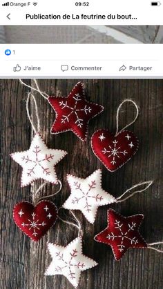 some red and white ornaments are hanging on a wooden table with string in the shape of snowflakes