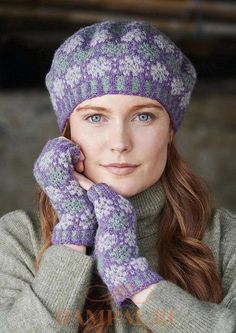 a woman with long red hair wearing purple gloves and a knitted hat is posing for the camera