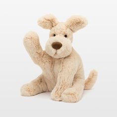 a teddy bear sitting on the ground with its paw up in the air and it's eyes closed