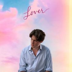 a man sitting on top of a chair in front of a colorful sky with the word love written above him