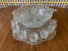 an antique glass bowl and matching set on a wooden table with a colorful rug in the background