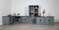 a kitchen with gray cabinets and wooden floors