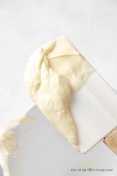 a white spatula filled with cream sitting on top of a counter