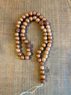 "Lovely old stock wood rosary beads from France, temporarily strung on jute twine. All \"hail mary\" or decades beads are round wood, with hand carved pater or \"our father\" beads at four stations in the rosary and appearing twice in the drop. Round beads measure approximately 8mm, and carved paters are approximately 9-10mm in diameter. Color is a lovely chestnut brown; some variation in bead size and color due to the handmade quality of these beads and some aging.  These beads are as they came Artisan Brown Beaded Necklaces With 8mm Beads, Spiritual Brown Beaded Necklace With Large Beads, Rustic Wooden Beads, Rustic Brown Beaded Necklace, Adjustable Wooden Beads, Brown Mala With Round Beads For Healing, Spiritual Rosary With Wooden Beads For Meditation, Spiritual Rosary With Large Beads, Handmade Brown Mala With Round Beads