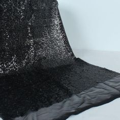 an image of black sequin fabric on display