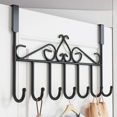 a coat rack with three coats hanging on it's sides and two purses next to it