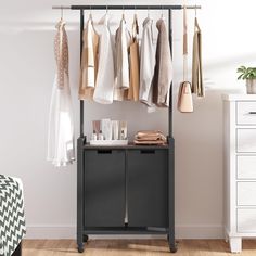 an organized closet with clothes hanging on the rack and other items in front of it