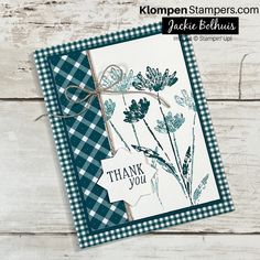 a thank you card with blue flowers and gingham ribbon on the front, sitting on a wooden surface