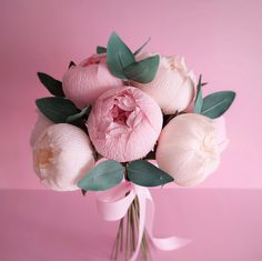 a bouquet of white and pink flowers on a pink background