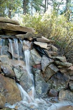 there is a waterfall in the middle of some rocks