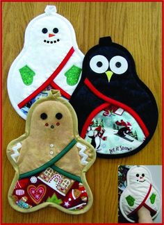 three oven mitts are decorated with christmas decorations and birds, one has a gingerbread cookie in the shape of a penguin