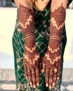 a woman's hands with hennap on her hand and the bottom half of her arm