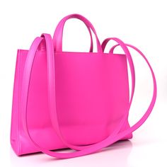 This is an authentic TELFAR Vegan Leather Medium Shopping Bag in Azalea. This is a tote crafted of synthetic leather in bright pink with the iconic raised Telfar logo at the front. The shoulder bag has short top handles, and two long shoulder straps. The top secures with a magnet snap and opens to a pink fabric lined interior with a pocket. Telfar Logo, Pink Fabric, White Bag, Synthetic Leather, Pink Bag, Bright Pink, Short Tops, Shoulder Straps, Vegan Leather