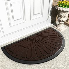 a brown door mat sitting on top of a floor next to a potted plant