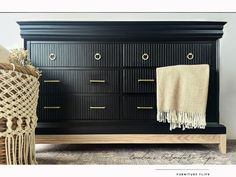 a black dresser with gold handles and drawers