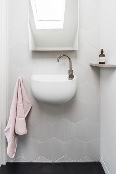 a white sink sitting under a bathroom window