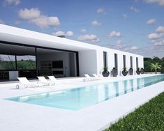 an empty swimming pool in front of a modern house