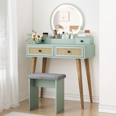 a blue vanity with drawers and a stool in front of it, next to a window