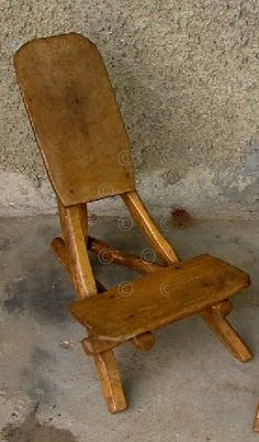 a wooden chair sitting on top of a cement floor