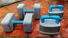 four cement blocks sitting on top of a red tile floor with blue piping attached to them