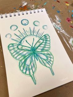 a drawing of a butterfly on paper with colored crayons