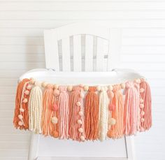 a white chair with tassels and pom poms on it