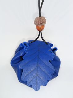 Medium Greek Blue Leather Oak Leaf Medicine Pouch, Celtic Tree Ogham, Lyrical Oak, Leather Pouch, Medicine Pouch, Pouch, Oak Leaf Medium handmade leather medicine pouch with wooden bead fastener for keeping crystals, trinkets, lucky charms and sentimental or magical items. The cord is long enough so you are able to adjust where it sits when around neck. Cord approx 100cm in length so when wearing the pouch the height of the pouch is roughly 45cm. The flap is an Oak leaf, which in the Celtic tree Blue Shoulder Bag With Zipper Pouch As Gift, Blue Travel Pouch Coin Purse, Handmade Blue Coin Purse For Travel, Blue Zipper Coin Purse As Gift, Handmade Blue Pouch For Everyday Use, Blue Handmade Pouch For Everyday Use, Blue Coin Purse With Removable Pouch, Handmade Blue Travel Pouch, Blue Clutch Coin Purse For Gift