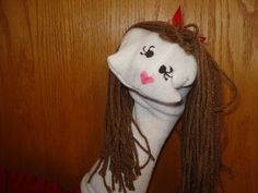 a white doll with long brown hair and pink nose