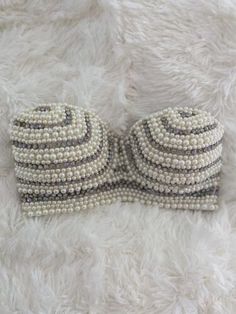 a close up of a bow tie made out of pearls on a white fur surface