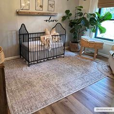 a baby crib in the corner of a room with a rug on the floor