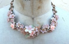 Delicate flowers and beads hand beaded together n pretty soft colors of peachy pink. The clusters of flowers include polymer clay roses and handpainted resin flowers with hand beaded leaves. The necklace itself is beaded in a diamond pattern, one of Colleen signature design elements. This is a beautiful piece for a pretty summer dress and a walk in the park. This is a quality piece of jewelry that will last a life time. Created by designer Colleen Toland who has been creating her unique style of Delicate Handmade Pink Flower Necklace, Pink Whimsical Jewelry With 3d Flowers, Handmade Pink Flower Necklace For Wedding, Pink Beaded Polymer Clay Jewelry, Pretty Summer Dresses, Beaded Leaf, Pink Necklace, Resin Flowers, Peachy Pink