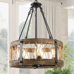 a chandelier made out of wood and rope with lights on it in front of a window