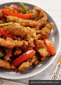 fried chicken with peppers and onions on a white plate