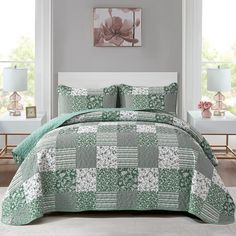 a green and white quilted bed in a room with two lamps on either side